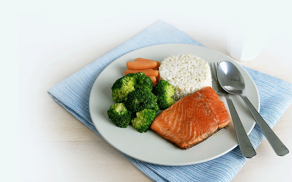 Healthy meal of baked salmon with broccoli and carrots and rice”
